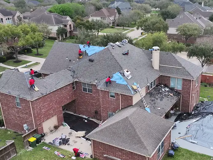3 S Roofing crew installing new shingles on the same two-story brick home