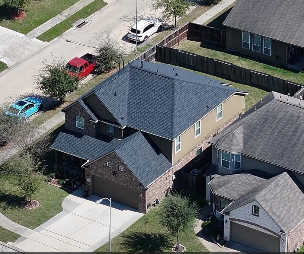 Vista aérea de una casa de dos pisos en el área de Houston con un techo de tejas terminado
