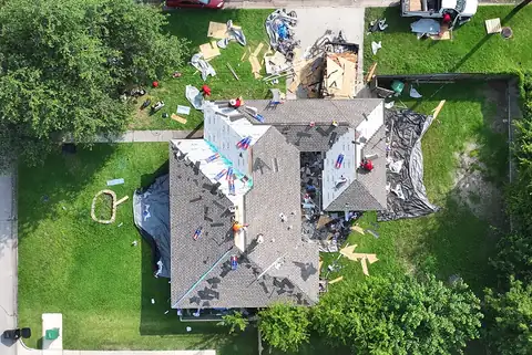 Crew installing new shingles over the underlayment on the same single-story home