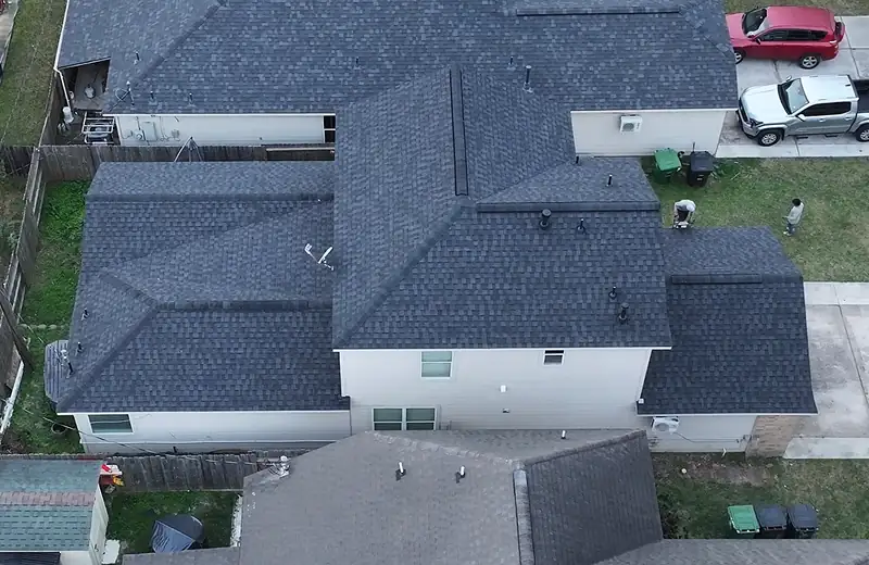 Two-story home in the Houston area from above with a completed dark shingle roof