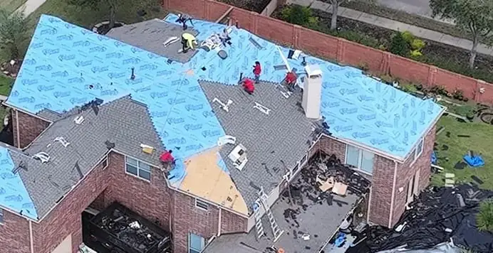 Foto de cerca de una chimenea, ventilas y tubos del techo con una cuadrilla trabajando