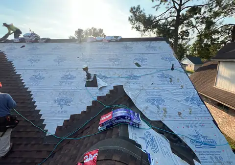 New underlayment and shingles being installed on the same roof