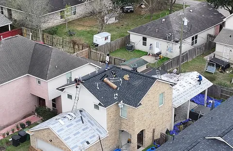 3 S Roofing crew working on several sections of the same two-story home